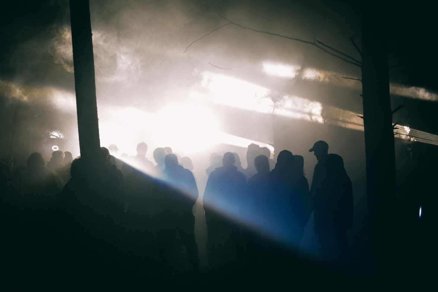 Silhouettes of Sustain-Release revelers walking towards the bright lights of the Grove.