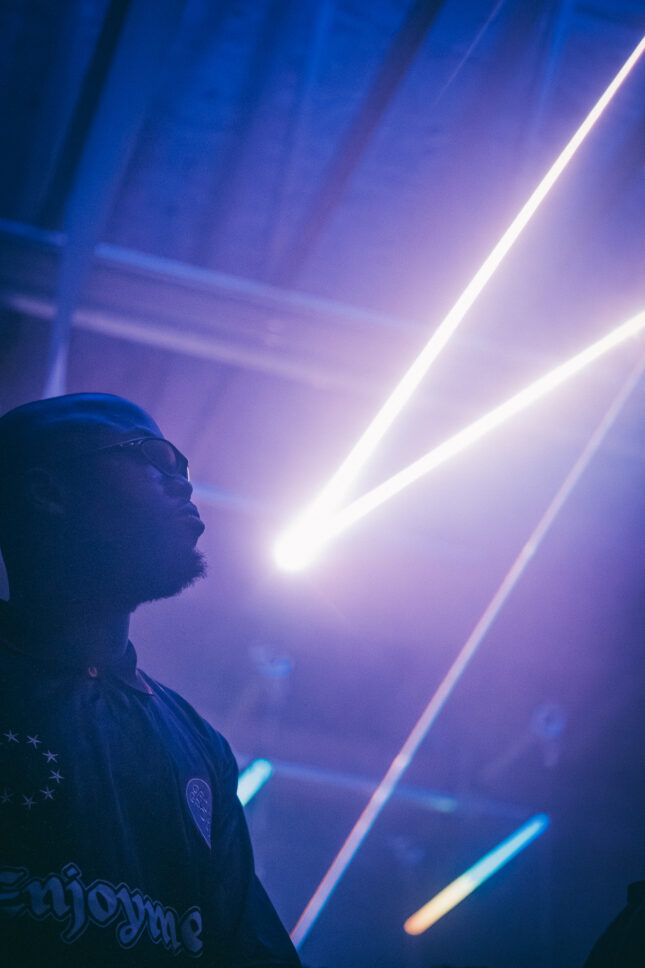 Akanbi of Groovy Groovy dancing with neon lights in the background in the Bossa Lounge of Sustain-Release.