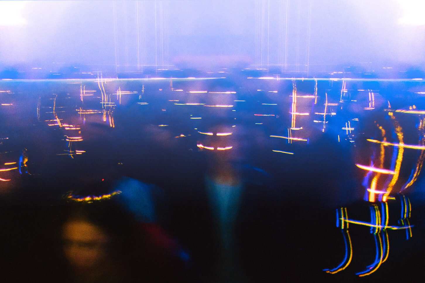 Sc-ifi like long exposure of blurry people dancing with dance floor lasers scanning across their faces at Sustain-Release year one.