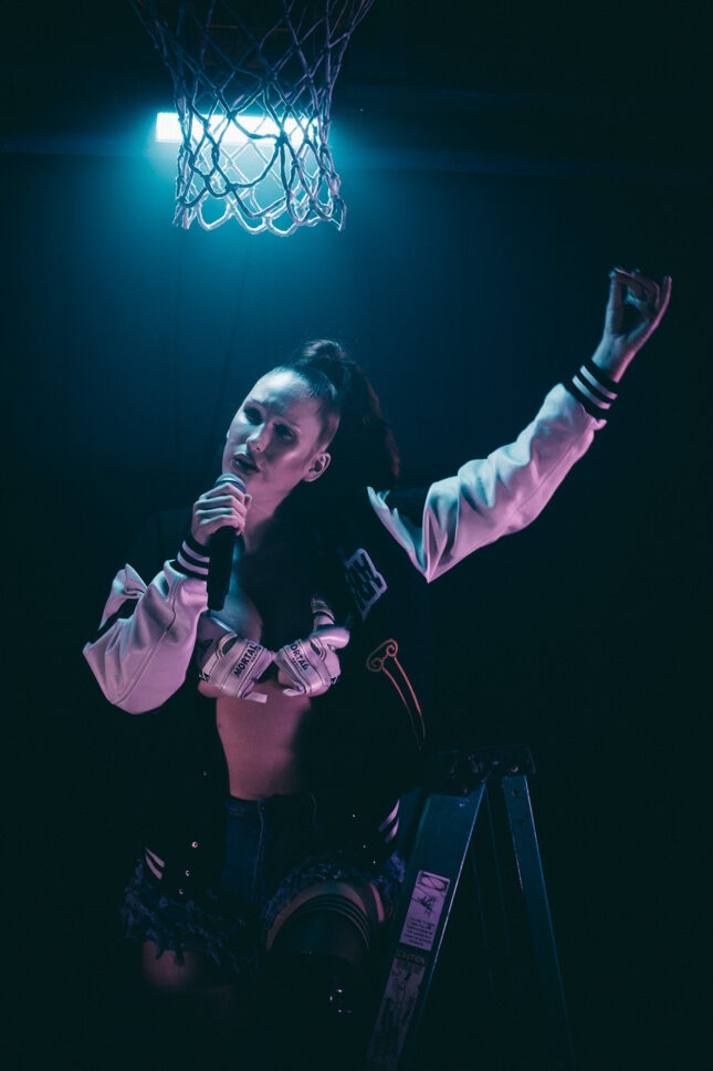 Earth Eater performs while standing on a ladder under the basketball hoop at the main stage of Sustain-Release.