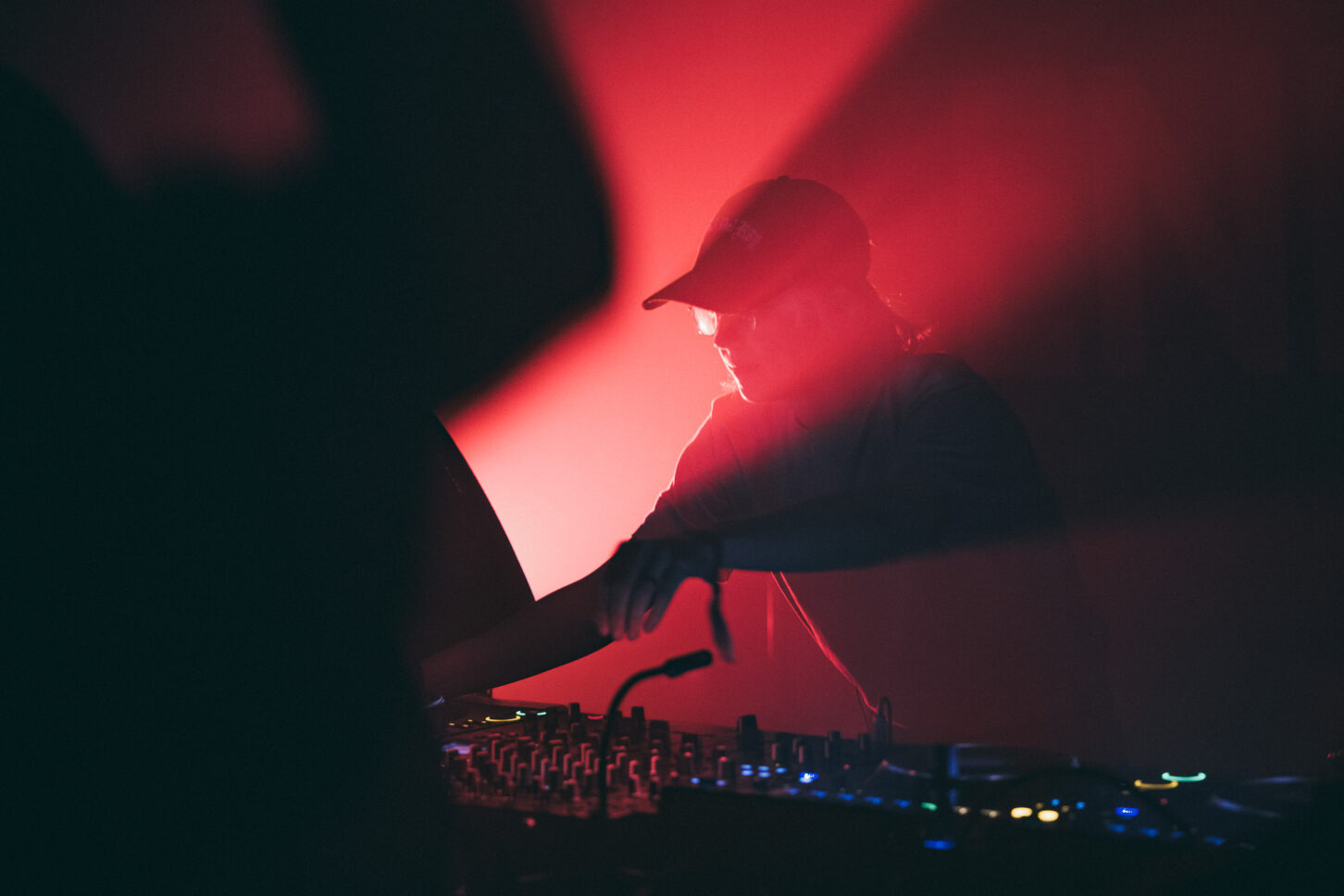 Avalon Emerson engulfed by red lights while playing the main stage of Sustain-Release.