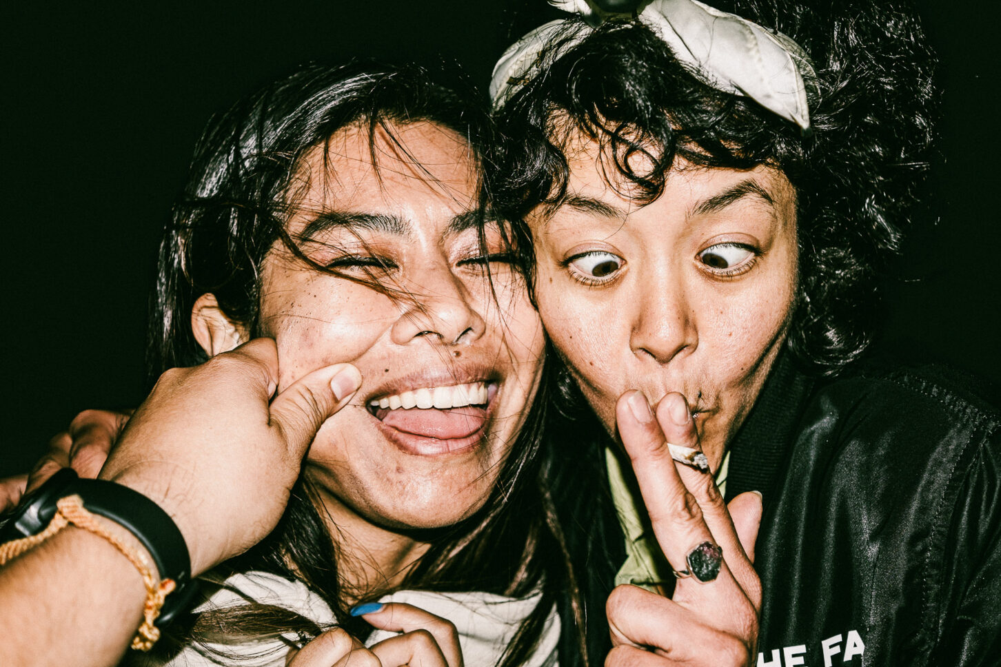 A subject making a goofy, exaggerated "duck face" reaction to a cheek pinch in this gritty, high-contrast 'Cheeky Bastards' photo.