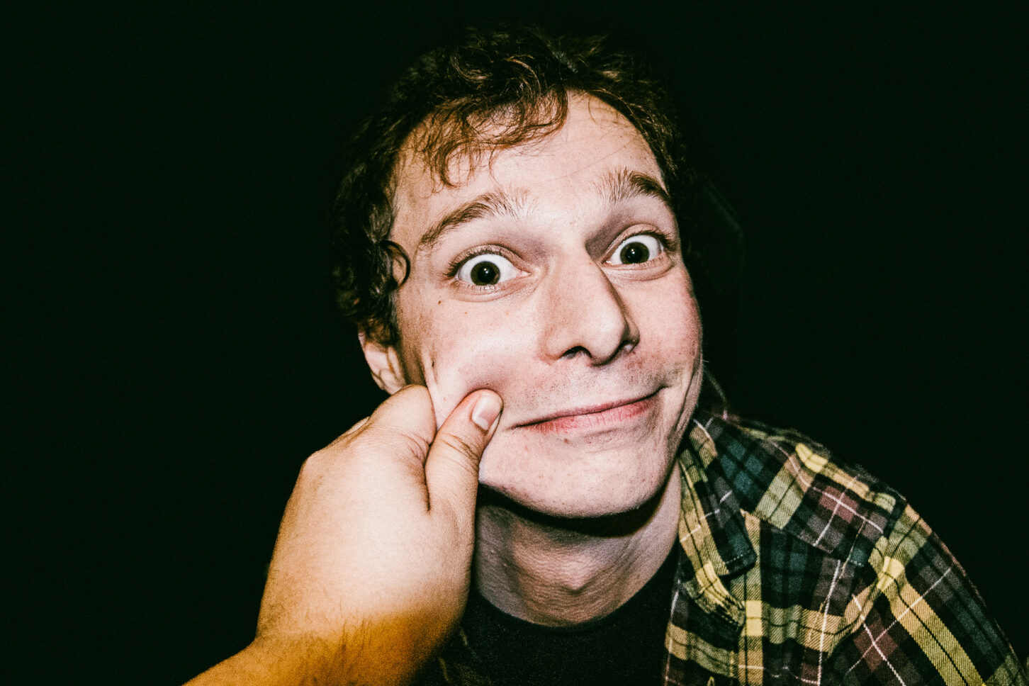 Close-up, raw portrait of a subject with a look of pure surprise, highlighting the high-energy and candid nature of the 'Cheeky Bastards' collection.