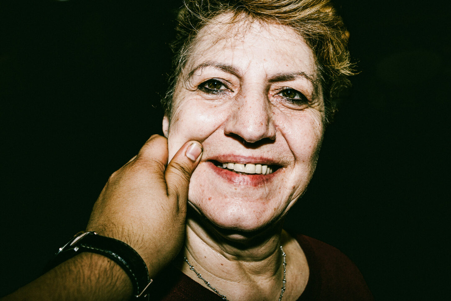 Tina from Tinas Dinner in Bushwick staring blankly at the camera with a "really?" expression while their cheek is pinched, adding humor to the 'Cheeky Bastards' collection.