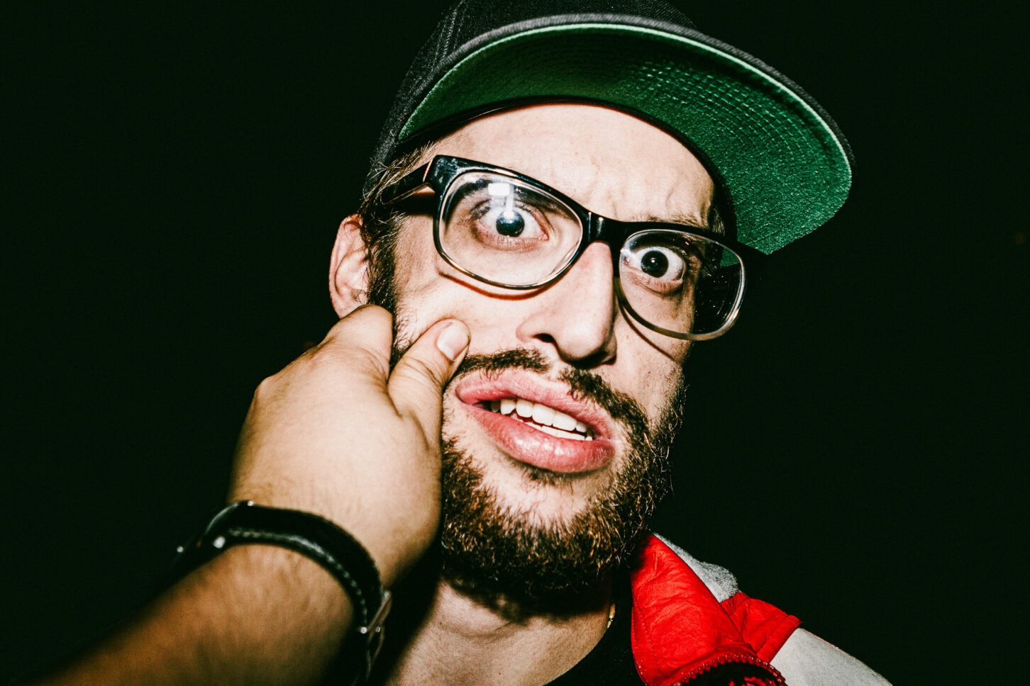 Close-up, raw portrait of a subject with a look of pure surprise, highlighting the high-energy and candid nature of the 'Cheeky Bastards' collection.