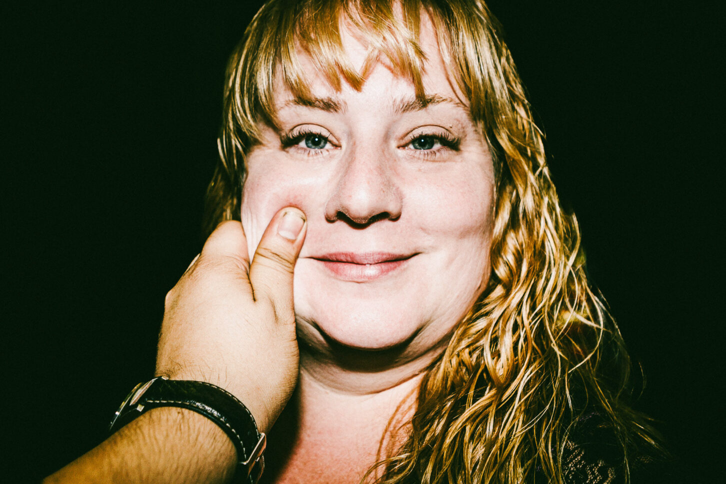 A subject staring blankly at the camera with a "really?" expression while their cheek is pinched, adding humor to the 'Cheeky Bastards' collection.