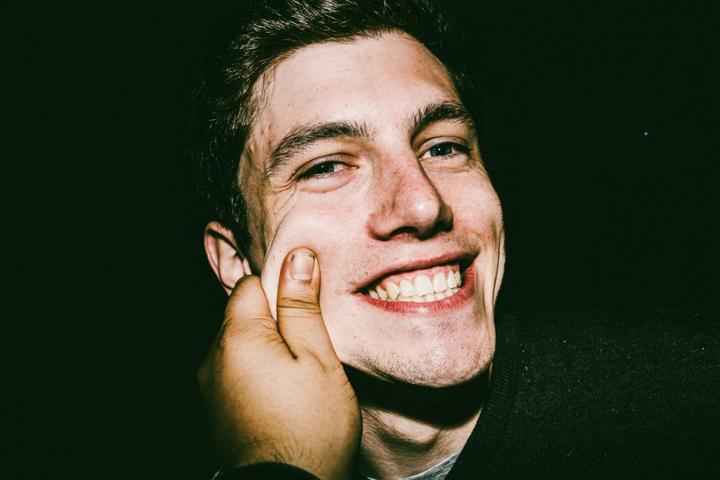 A man roaring with laughter, head thrown back, in a high-energy flash portrait from the 'Cheeky Bastards' collection.
