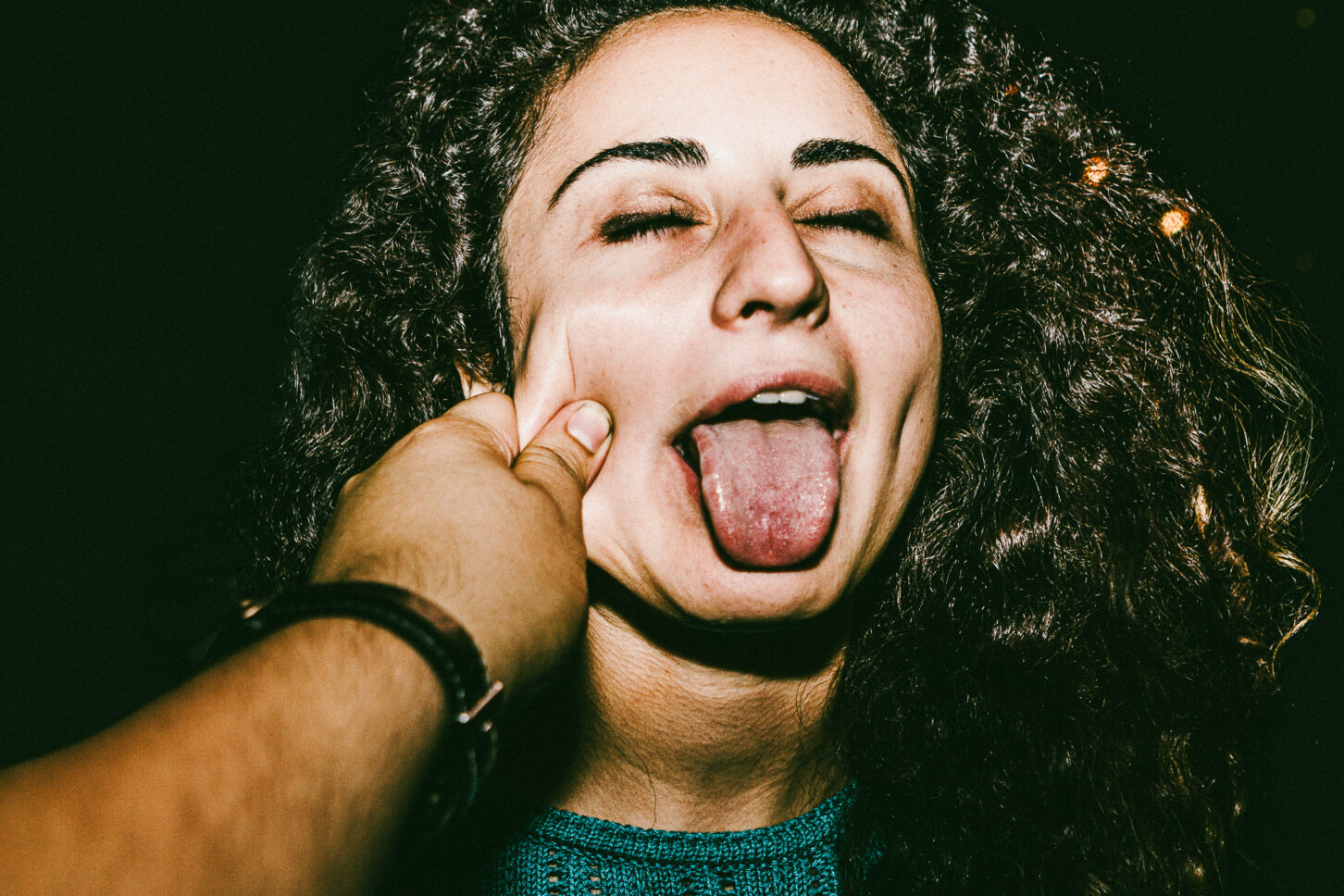 A subject sticking their tongue out playfully in a rebellious, gritty portrait for the 'Cheeky Bastards' series.