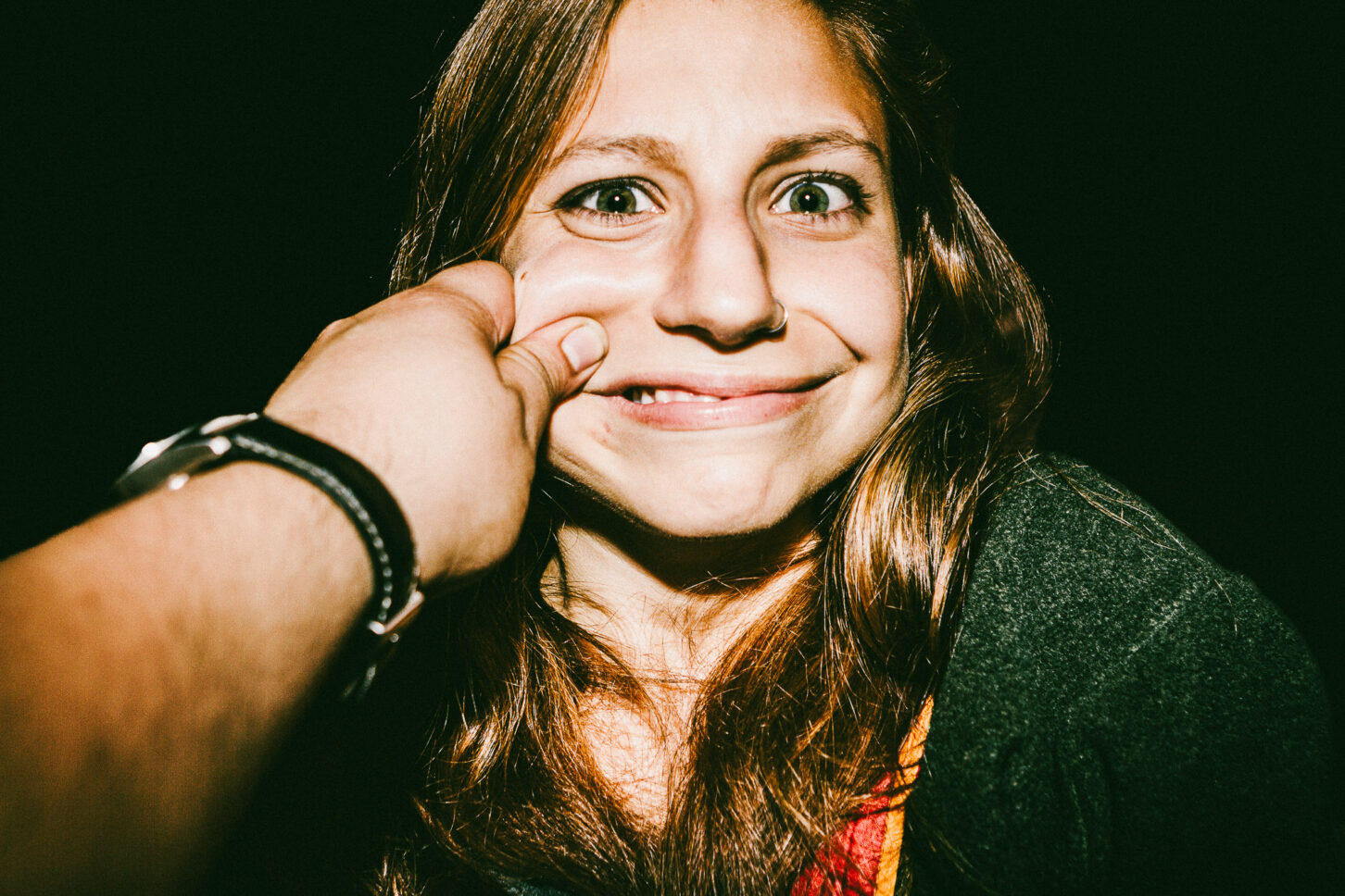 A subject attempting to keep a straight face but failing, with a smirk breaking through in this 'Cheeky Bastards' close-up.