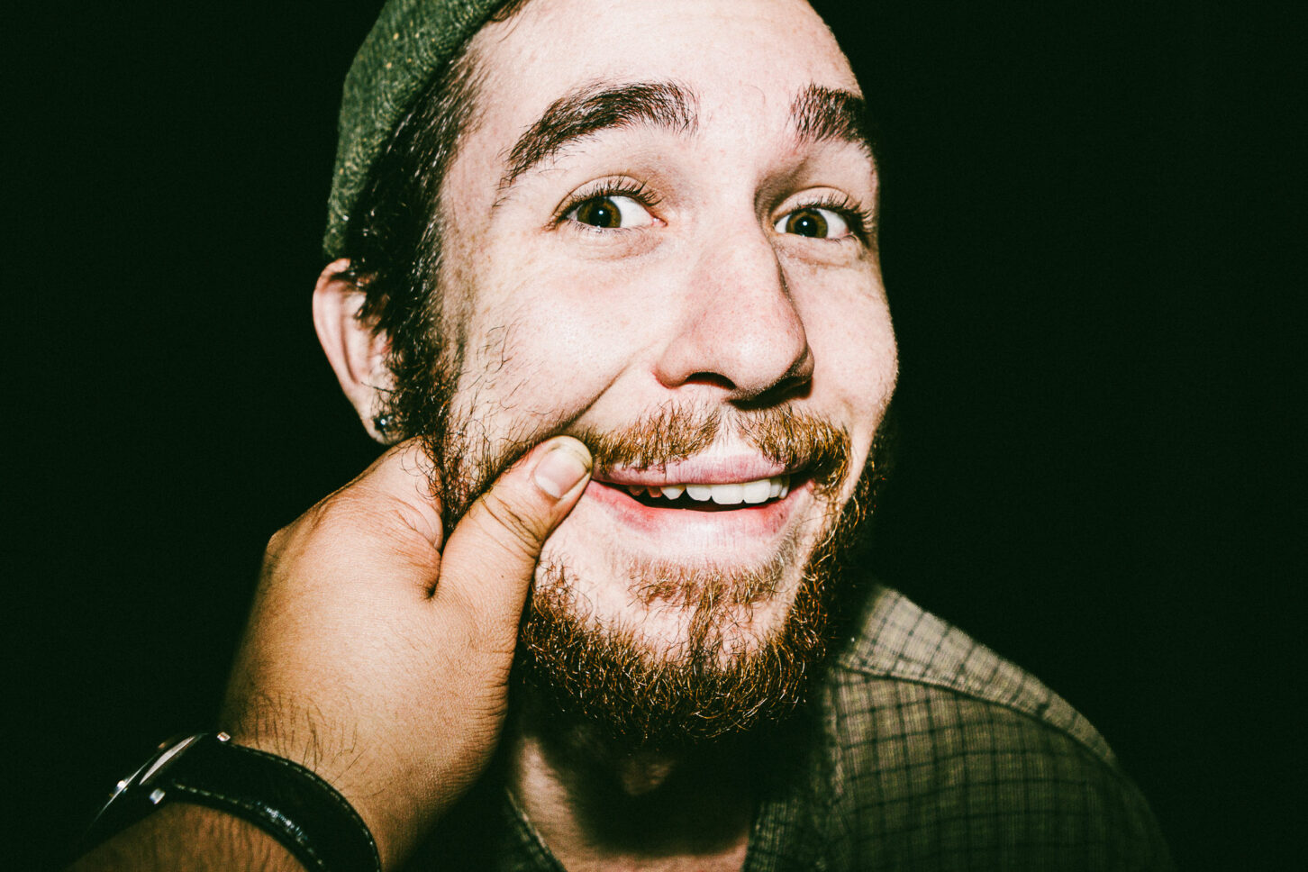 A shot focusing on the subject's laughter lines and squinted eyes, emphasizing the human joy in this 'Cheeky Bastards' reaction shot.