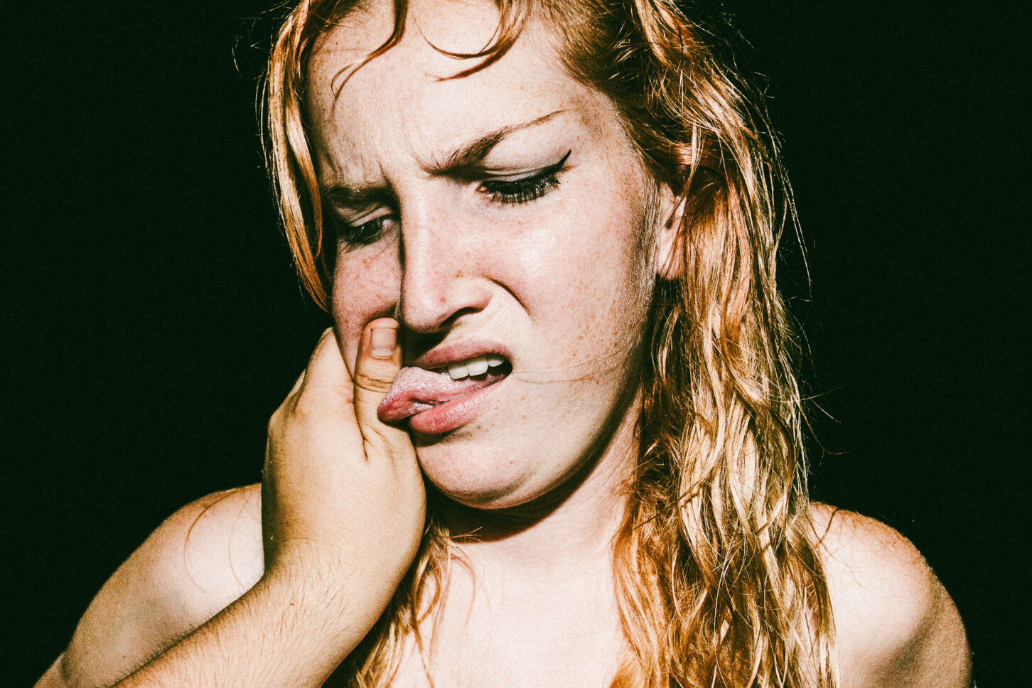 A subject sticking their tongue out playfully in a rebellious, gritty portrait for the 'Cheeky Bastards' series.